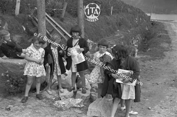 CHILDREN WAITING IN GROUP AT SIDE OF ROAD